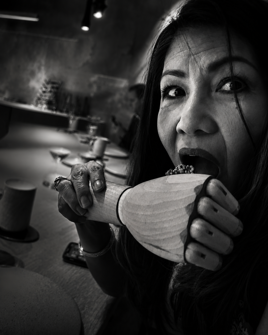 Rose enjoying a meal in a black-and-white restaurant portrait
