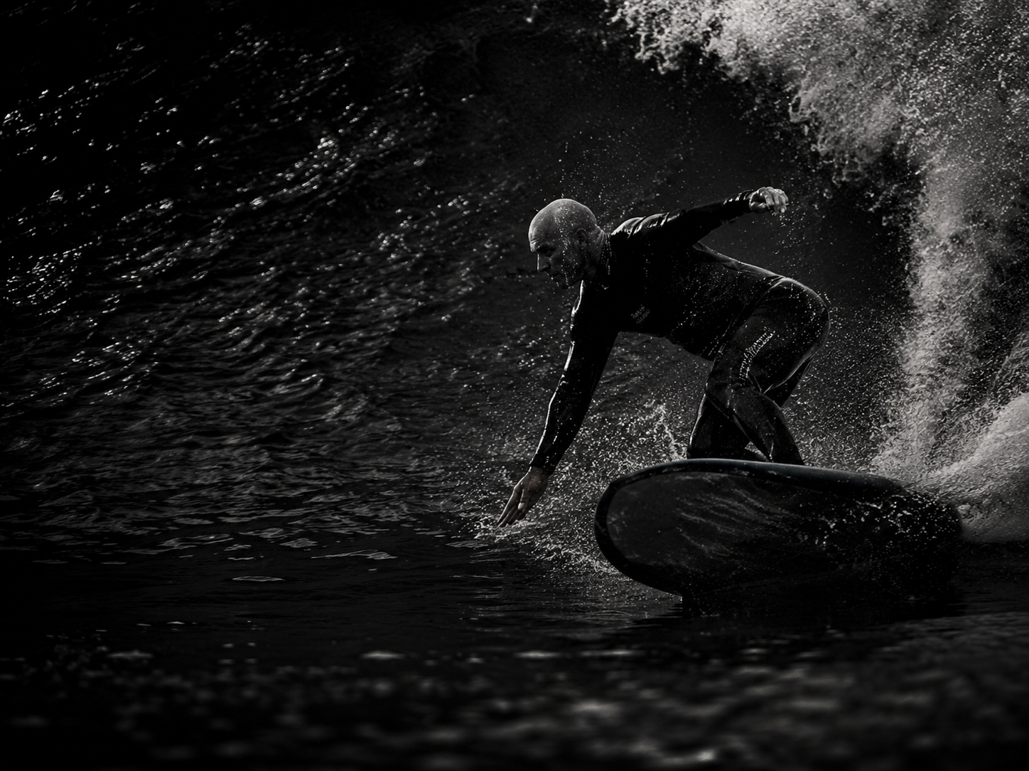 Ashley Mason surfing a wave in black and white